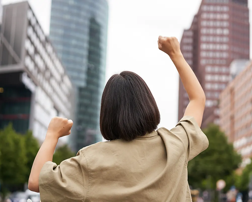 excitement-happy-girl-rear-view-raising-her-hands-up-looking-big-city-skyscrappers-feeling-co